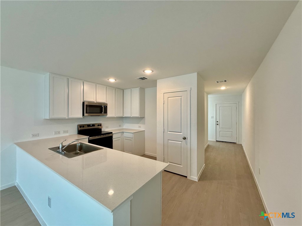 413 Moscato Road New Braunfels, TX 78130 - Photo 4 of 28 a kitchen with stainless steel appliances a refrigerator sink and microwave