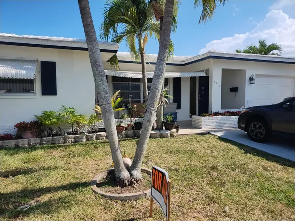 a view of a house with backyard and trees
