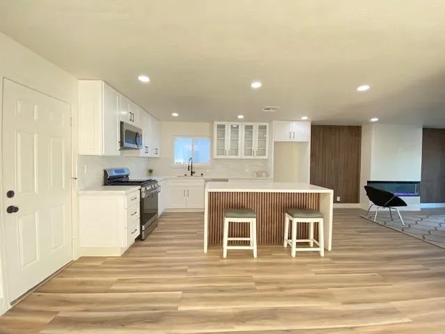 a kitchen with stainless steel appliances granite countertop a stove a sink and a refrigerator