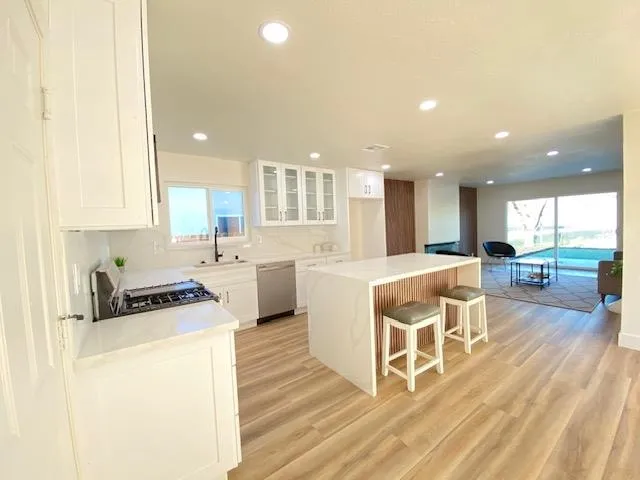 a kitchen with a sink cabinets and wooden floor