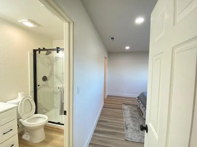 a bathroom with a granite countertop sink toilet and shower
