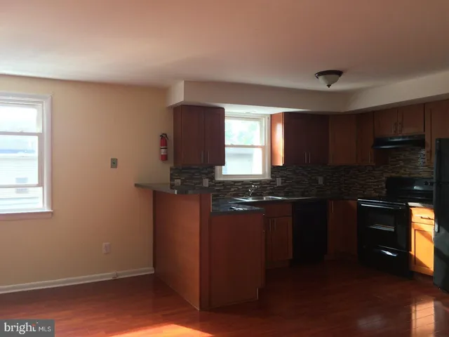 a kitchen with granite countertop stainless steel appliances a stove refrigerator and cabinets