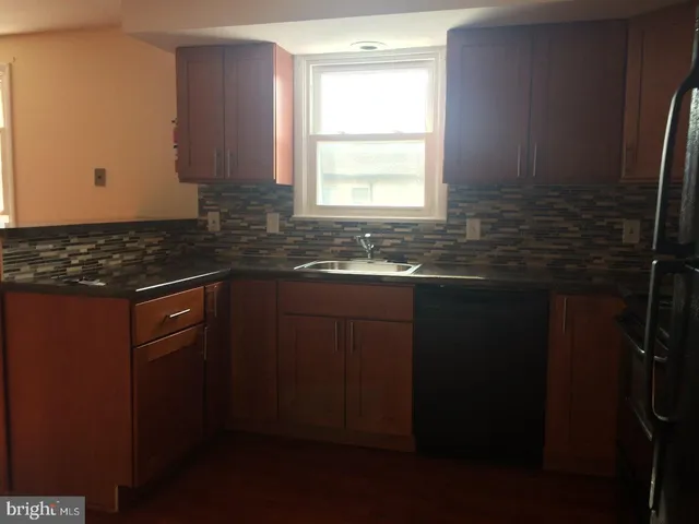 a kitchen with a sink a window and cabinets