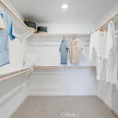 a view of walk in closet with clothes and shoes