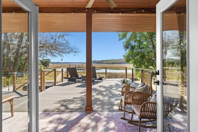 a outdoor space with lots of chairs a glass door and a table