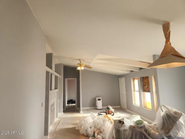 a bedroom with a bed large window and a chandelier