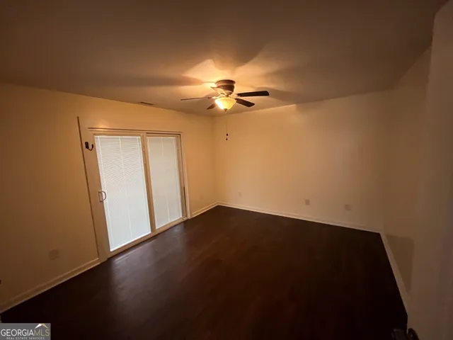 an empty room with a ceiling fan and a window