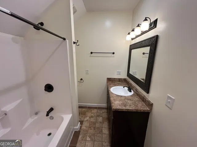 a bathroom with a granite countertop sink and a mirror