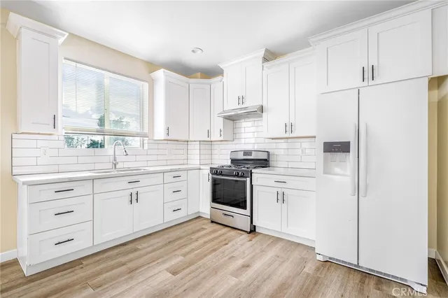 a kitchen with white cabinets and white appliances