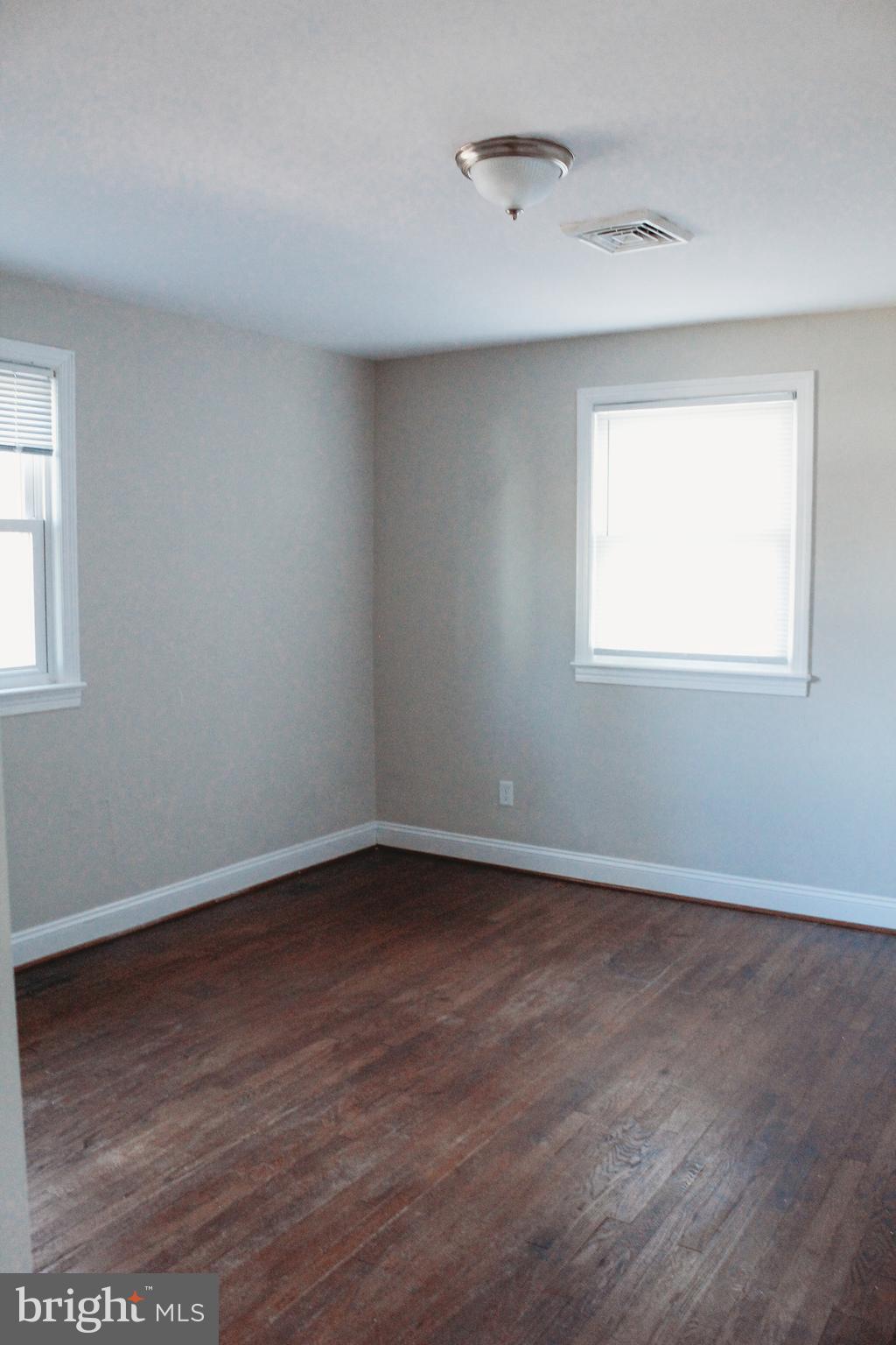 9101 Sudley Road Manassas, VA 20110 - Photo 9 of 19 an empty room with wooden floor and windows