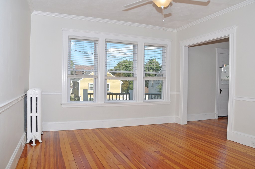 135-137 Thacher Street, Unit 2 Milton, MA 02186 - Photo 4 of 11 a view of an empty room with wooden floor and a window