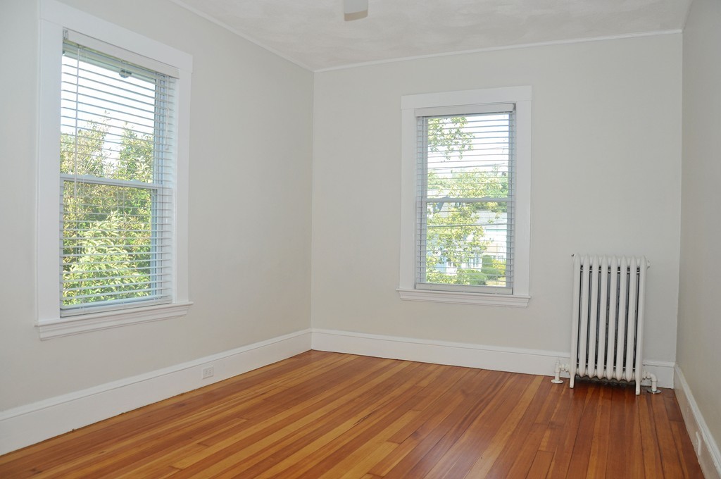 135-137 Thacher Street, Unit 2 Milton, MA 02186 - Photo 8 of 11 a view of an empty room with wooden floor and a window