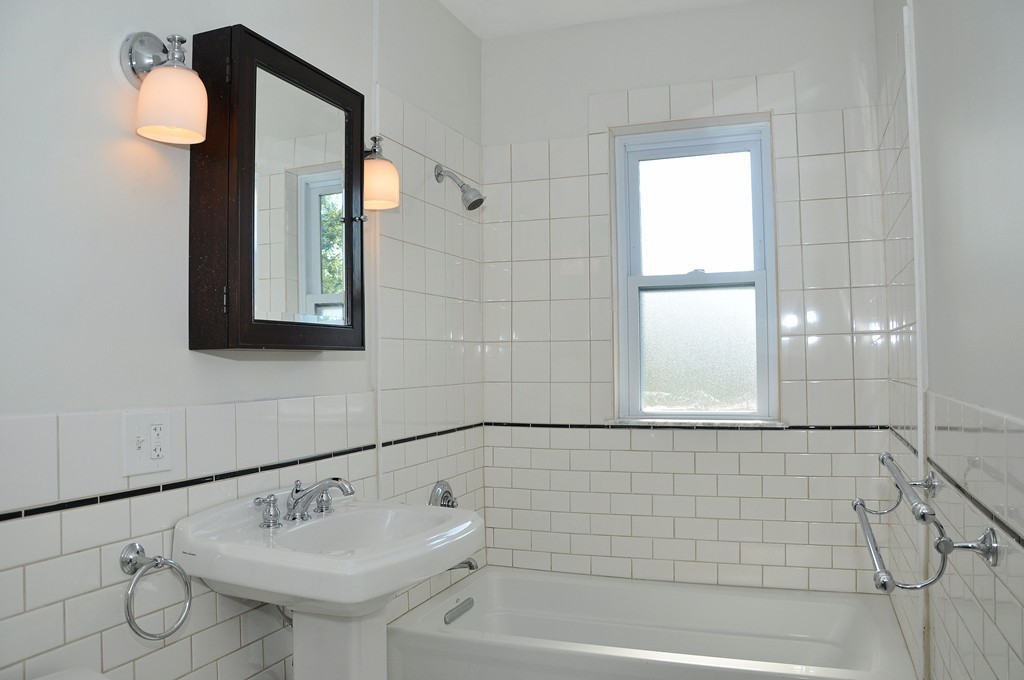 135-137 Thacher Street, Unit 2 Milton, MA 02186 - Photo 9 of 11 a bathroom with a sink a mirror and a bathtub
