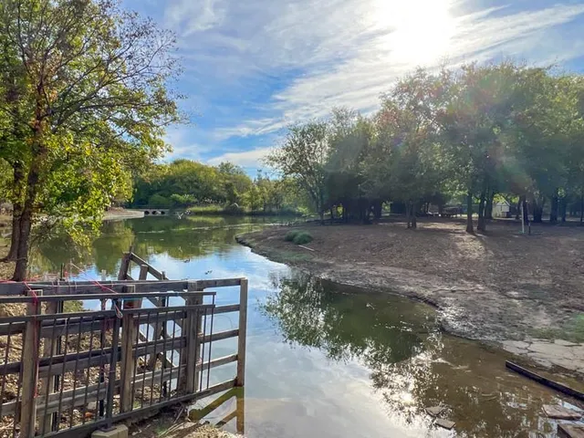 a view of a lake with a bench next to yard