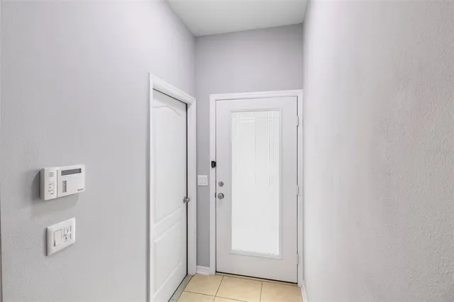 an empty room with chandelier fan and windows