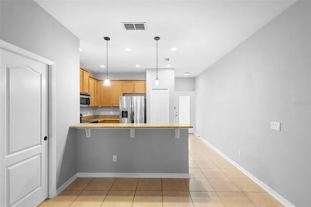 an empty room with chandelier fan and windows