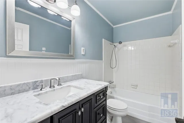 a bathroom with a granite countertop sink a toilet and shower