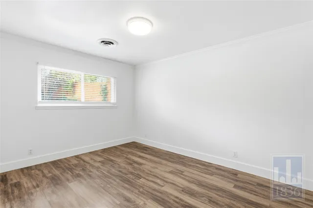 wooden floor in an empty room with a window