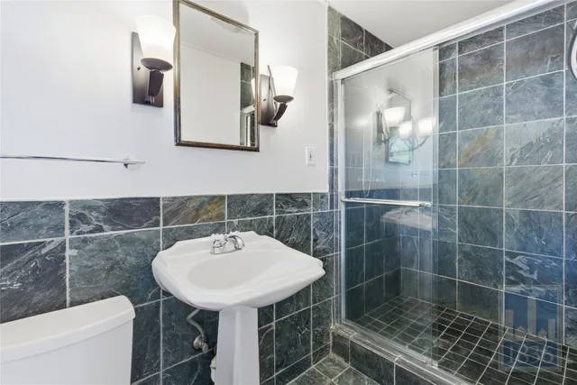 a bathroom with a sink a toilet and shower