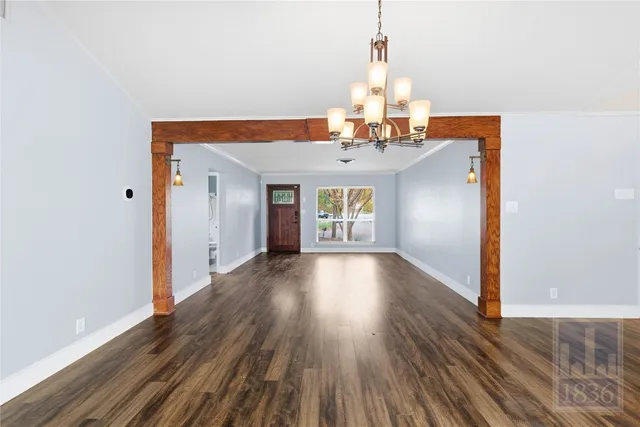 a view of a room with wooden floor and chandelier