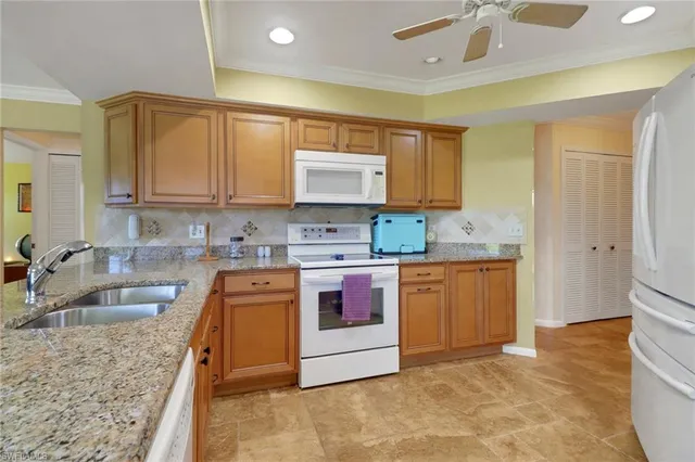 a kitchen with stainless steel appliances granite countertop a stove a sink and a refrigerator