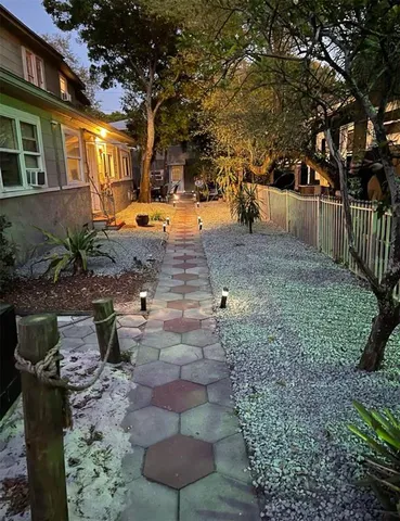 a view of a yard with plants and trees