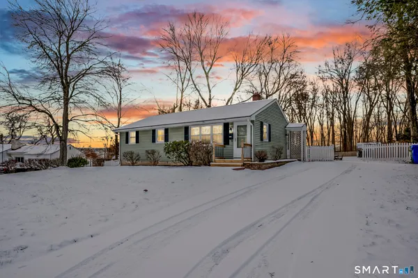 a front view of a house with a yard covered in snow