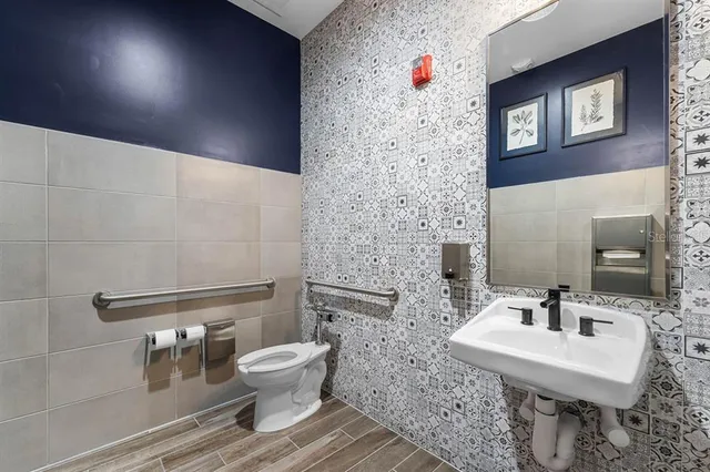 a bathroom with a toilet a sink and mirror