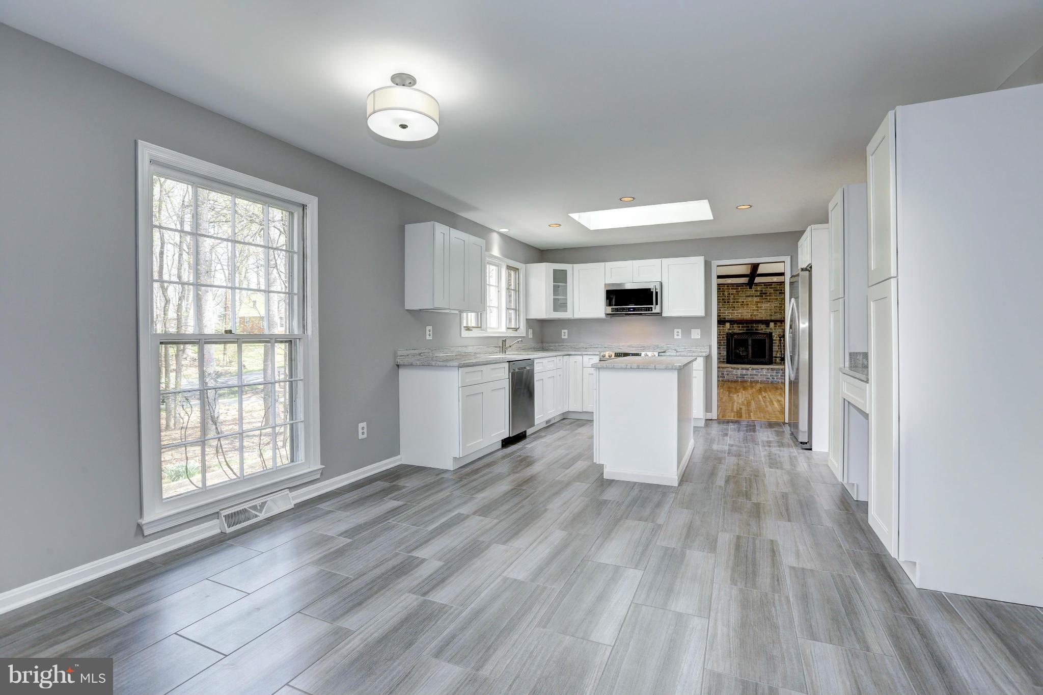 13116 Brandon Way Road Gaithersburg, MD 20878 - Photo 6 of 30 a kitchen with a refrigerator a stove top oven a sink and white cabinets with wooden floor