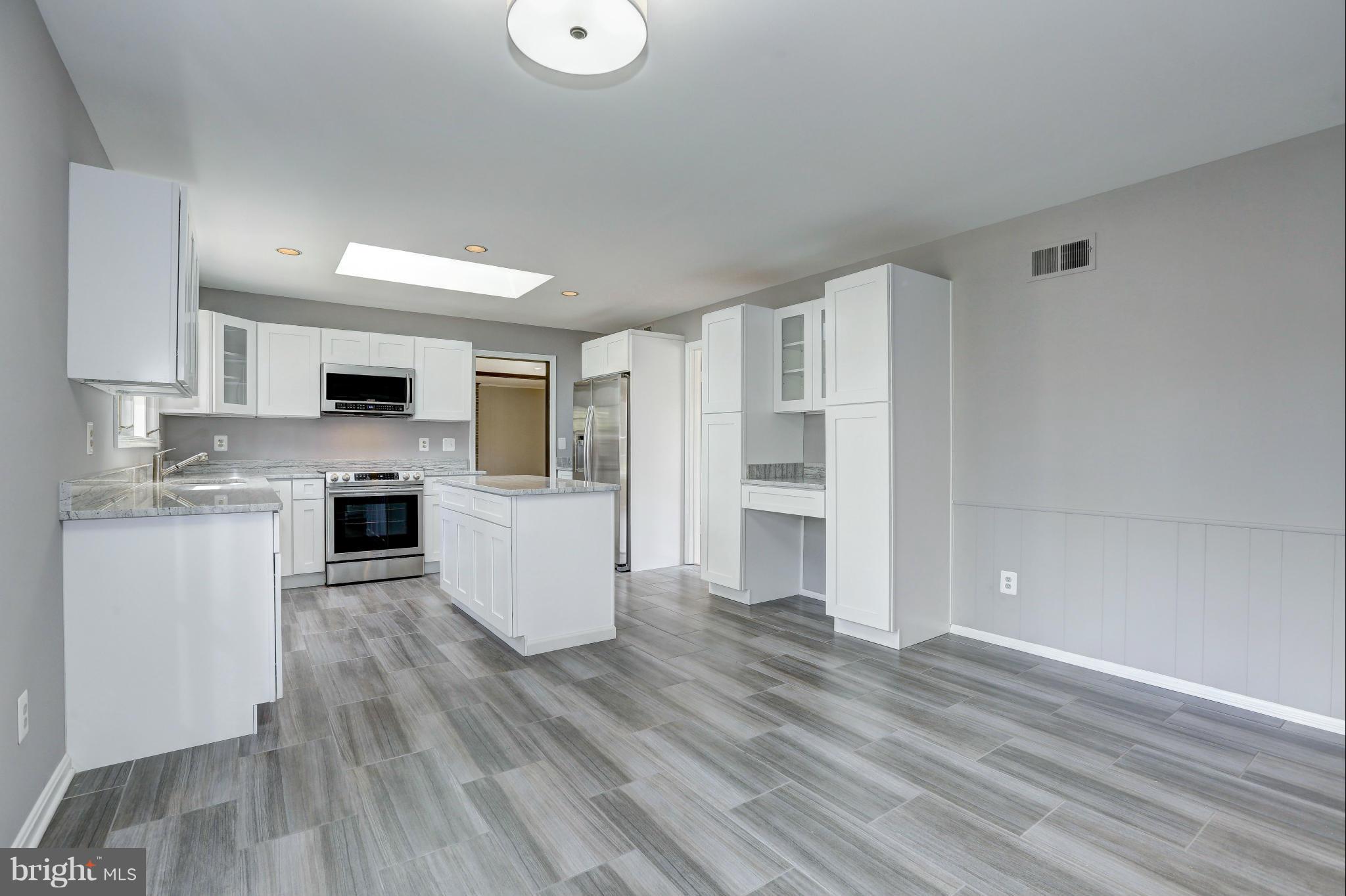 13116 Brandon Way Road Gaithersburg, MD 20878 - Photo 7 of 30 a kitchen with white cabinets and stainless steel appliances
