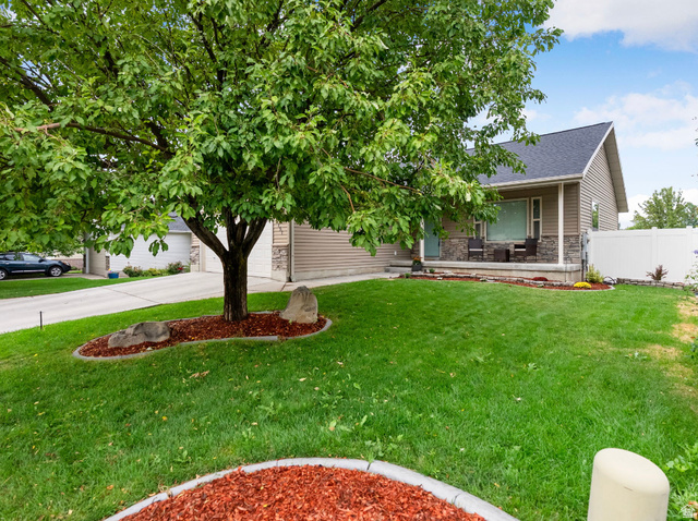 151 360 North Providence, UT 84332 - Photo 1 of 1 Obstructed view of property featuring stone siding, driveway, a shingled roof, and an attached garage