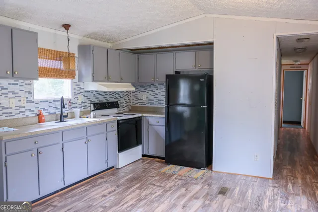 a kitchen with stainless steel appliances granite countertop a refrigerator and a sink
