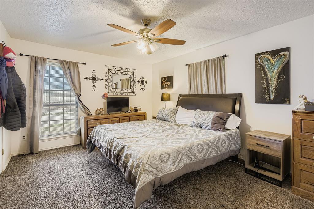 6232 North Ridge Road Fort Worth, TX 76135 - Photo 17 of 29 a bedroom with a bed a couch and dresser