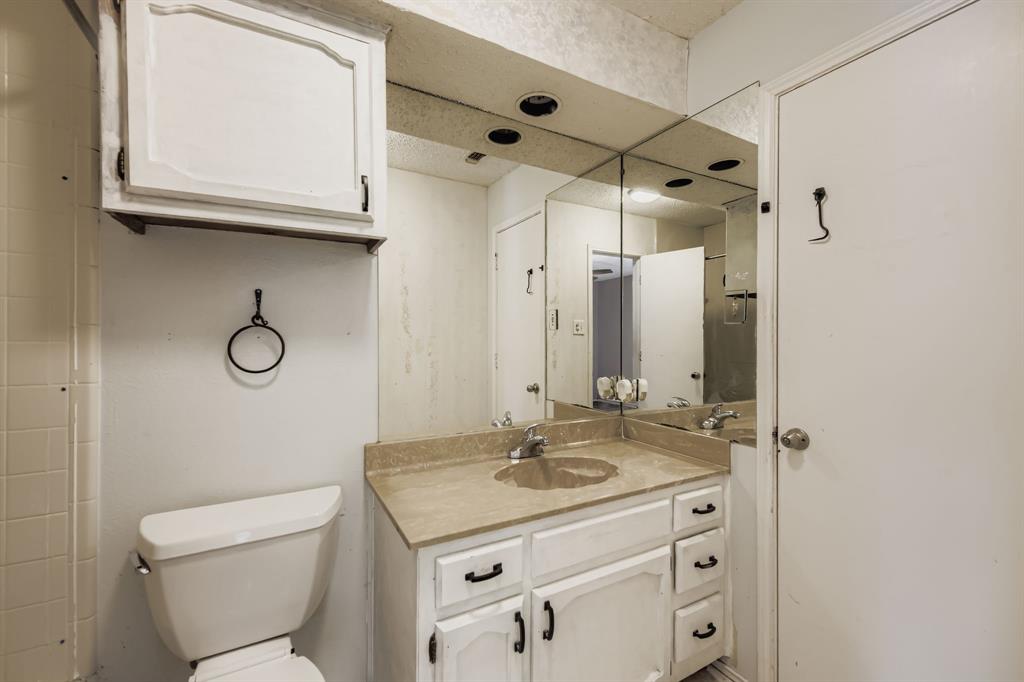 6232 North Ridge Road Fort Worth, TX 76135 - Photo 20 of 29 a bathroom with a granite countertop sink a mirror and a toilet