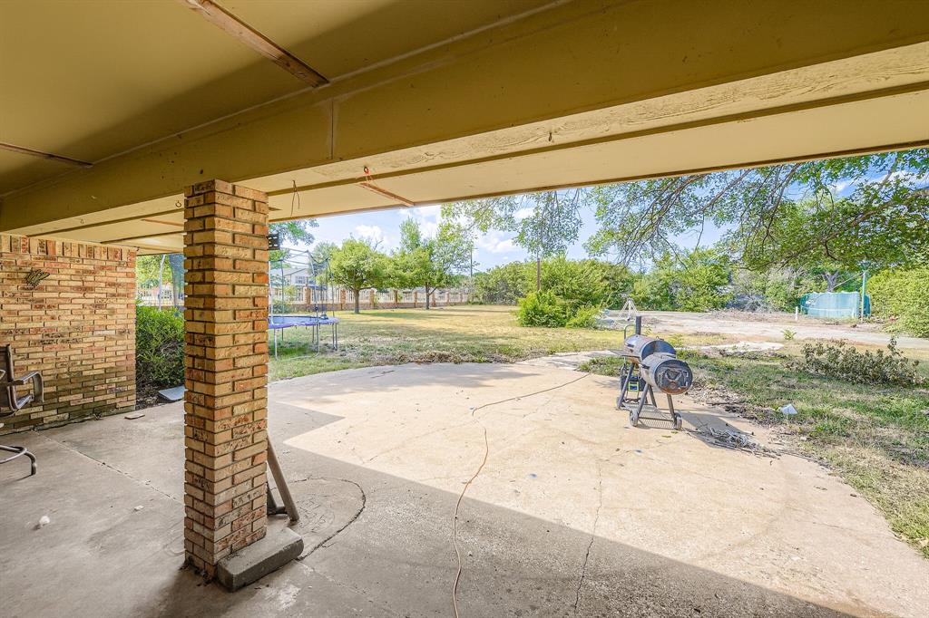 6232 North Ridge Road Fort Worth, TX 76135 - Photo 24 of 29 a view of backyard with a large window and potted plants
