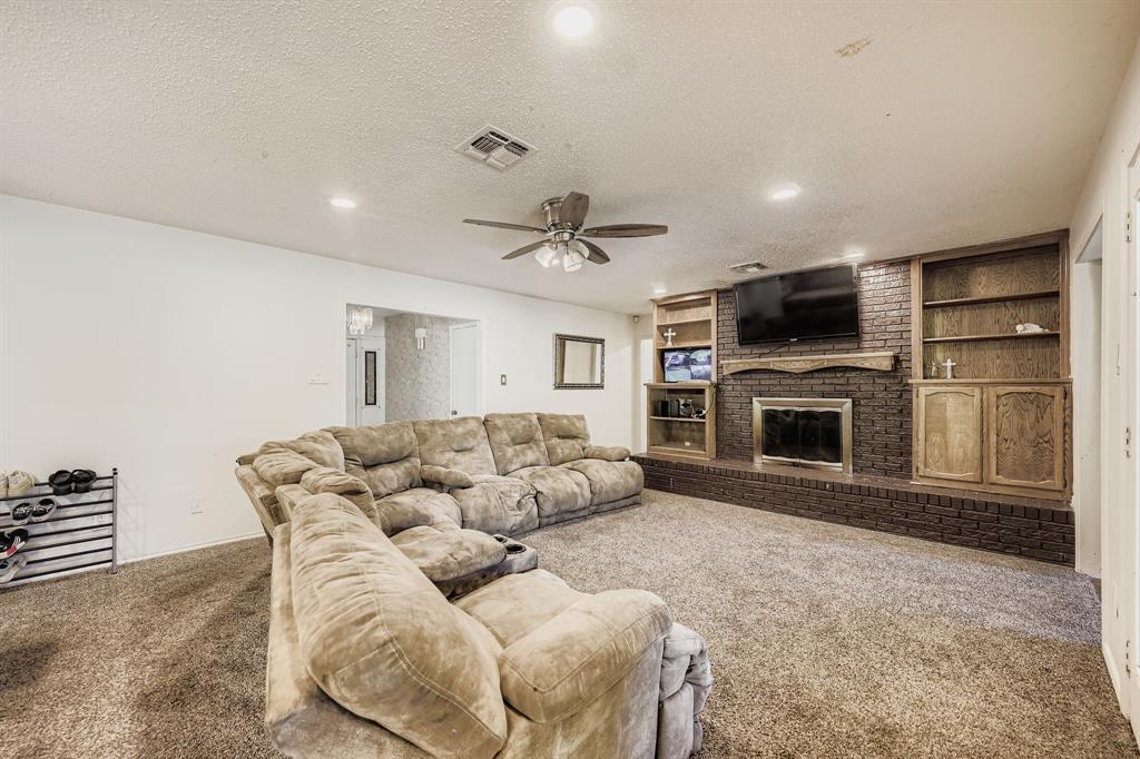 6232 North Ridge Road Fort Worth, TX 76135 - Photo 4 of 29 a living room with furniture a fireplace and a flat screen tv