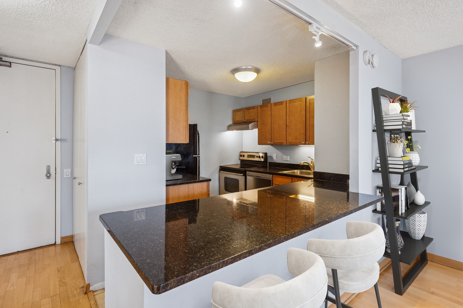30 East Huron Street, Unit 2003 Chicago, IL 60611 - Photo 6 of 24 a kitchen with stainless steel appliances granite countertop a sink dishwasher and cabinets with wooden floor