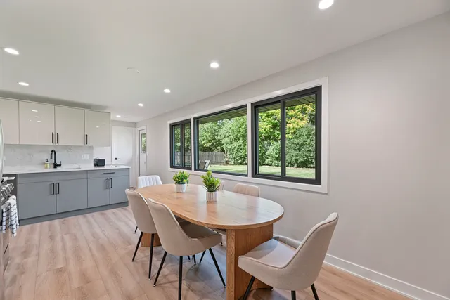a kitchen with a table chairs sink and cabinets