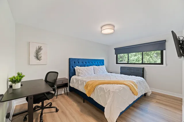 a bedroom with a bed and a potted plant