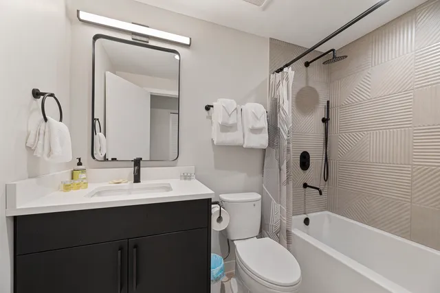 a bathroom with a sink vanity mirror and toilet