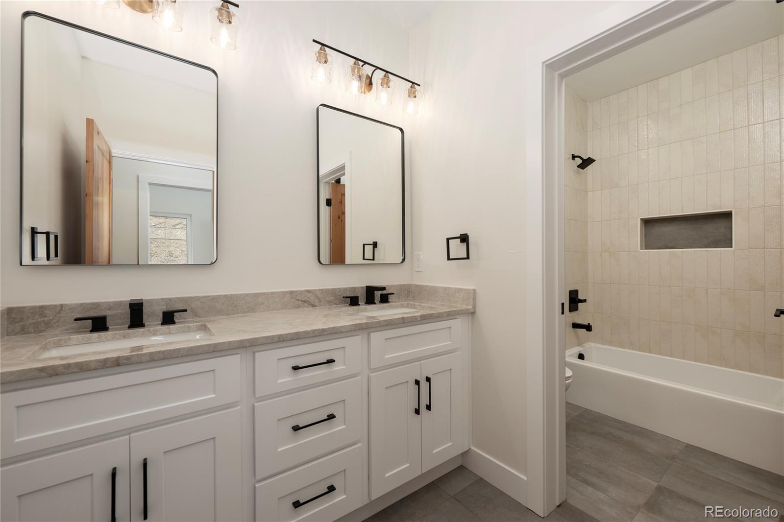 622 Upper Ranch View Drive Granby, CO 80446 - Photo 30 of 50 a bathroom with a double vanity sink and mirror with bathtub