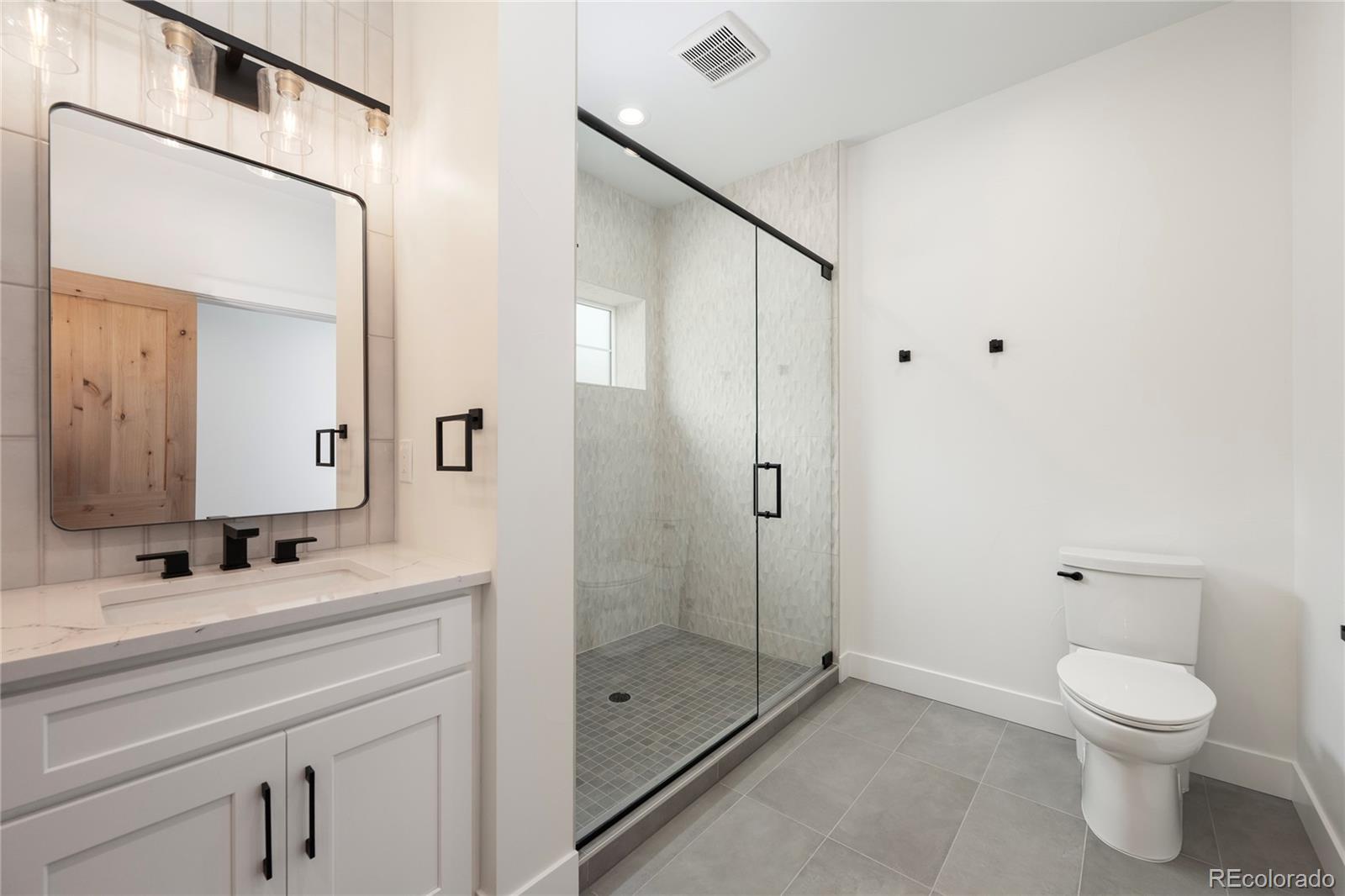 622 Upper Ranch View Drive Granby, CO 80446 - Photo 35 of 50 a bathroom with a toilet a sink a mirror and shower