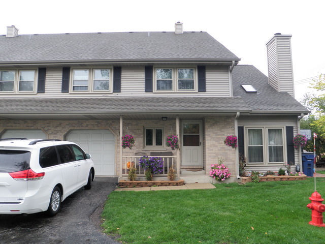 a front view of a house with a garden and plants