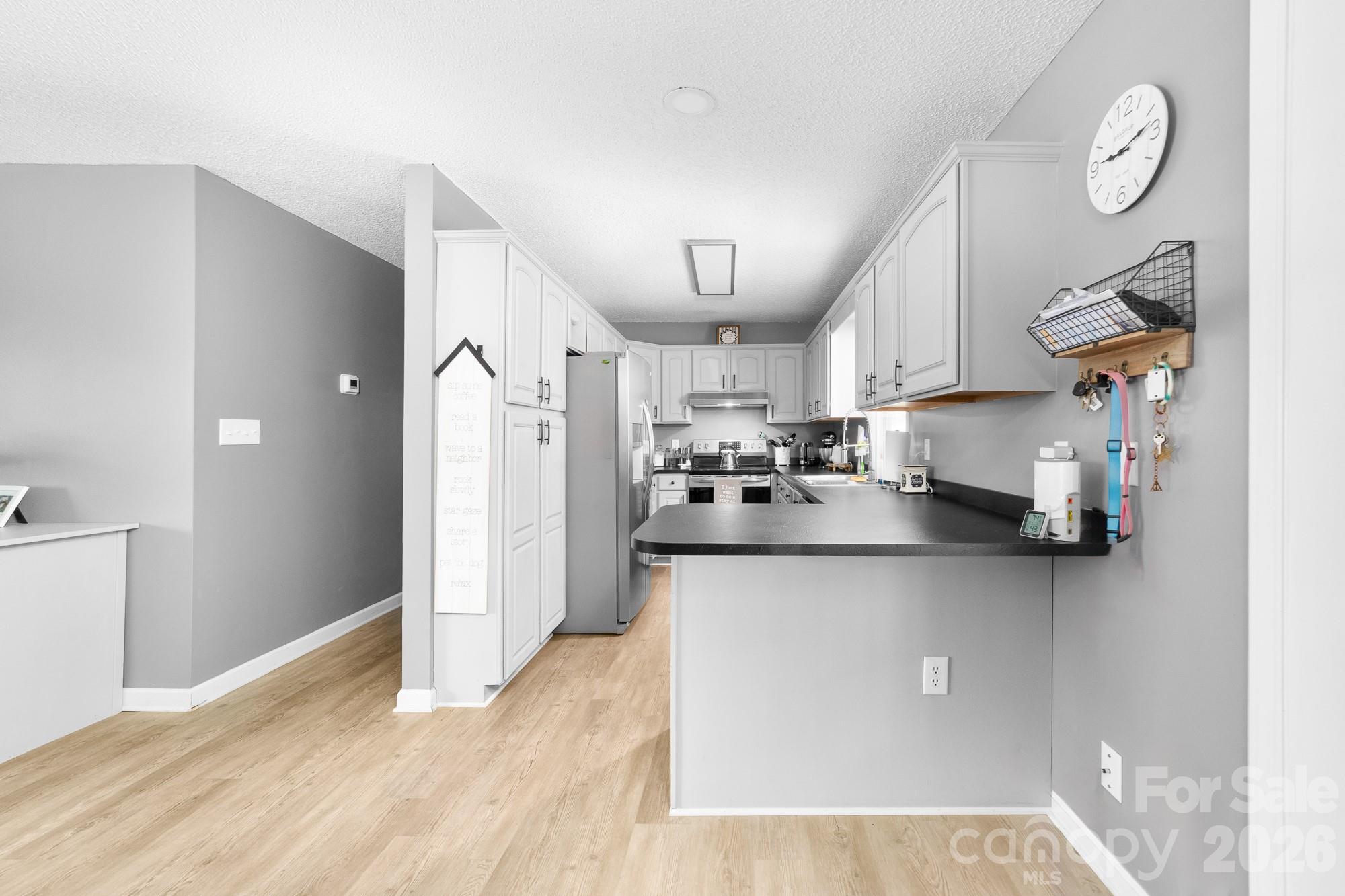 248 Jack McKinney Road Forest City, NC 28043 - Photo 22 of 29 a kitchen with stainless steel appliances granite countertop a refrigerator a sink dishwasher a stove and a dining table with wooden floor