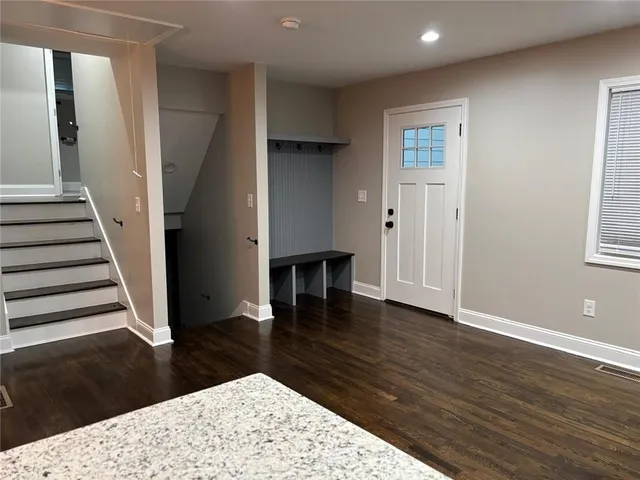 wooden floor view with staircase and front door