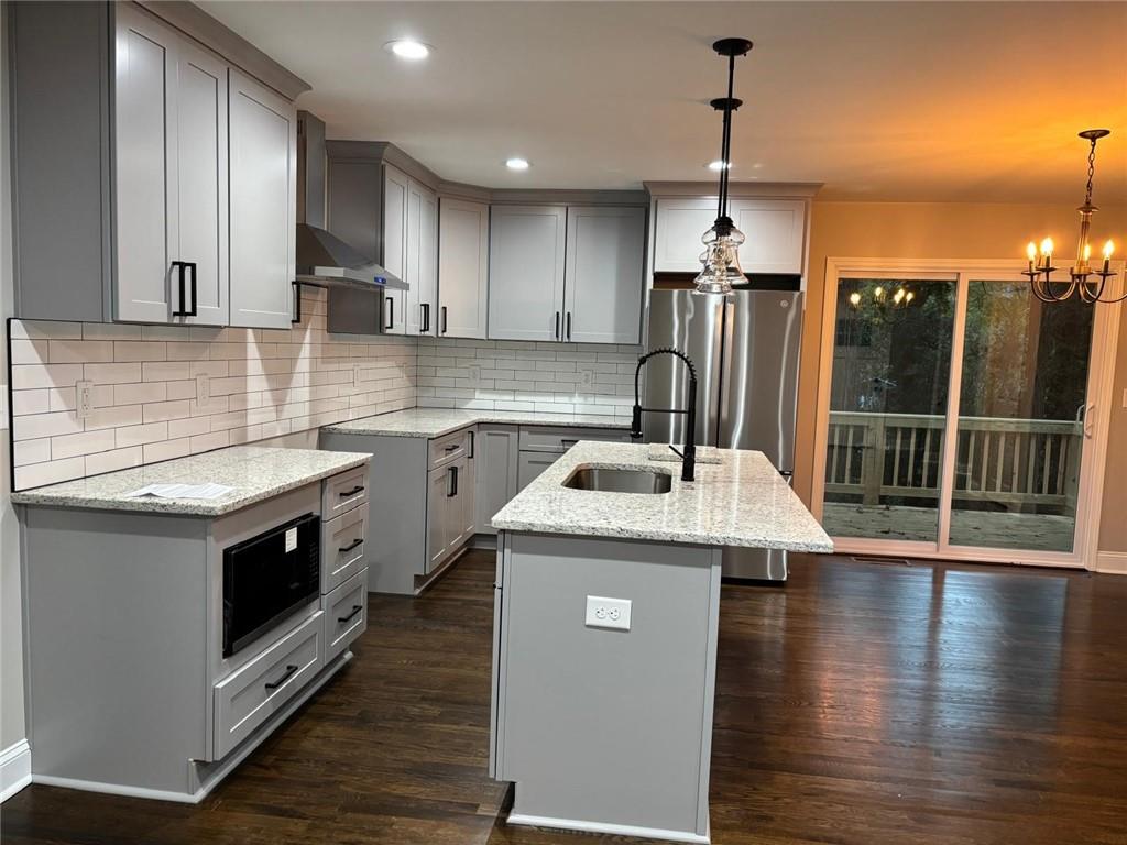 2485 Ortega Way Chamblee, GA 30341 - Photo 4 of 27 a kitchen with a sink stove and wooden floor