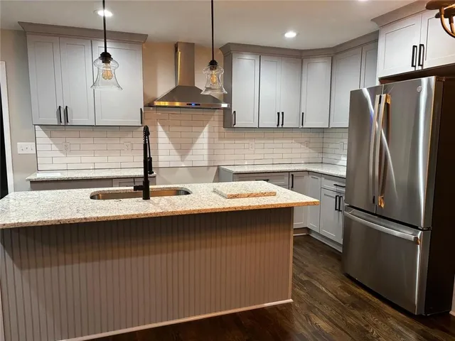 a kitchen with kitchen island stainless steel appliances a sink and a refrigerator