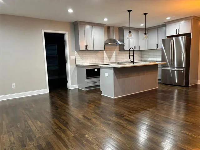 a kitchen with kitchen island granite countertop stainless steel appliances refrigerator sink and stove