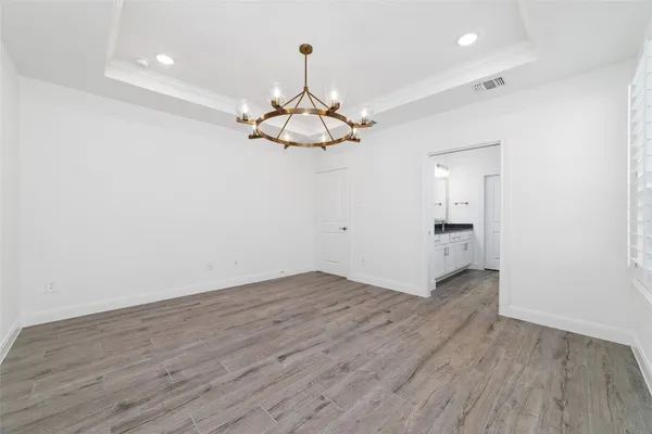 a view of a room with wooden floor and ceiling fan