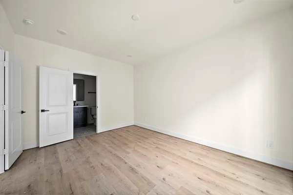 a view of a hallway with wooden floor and entryway